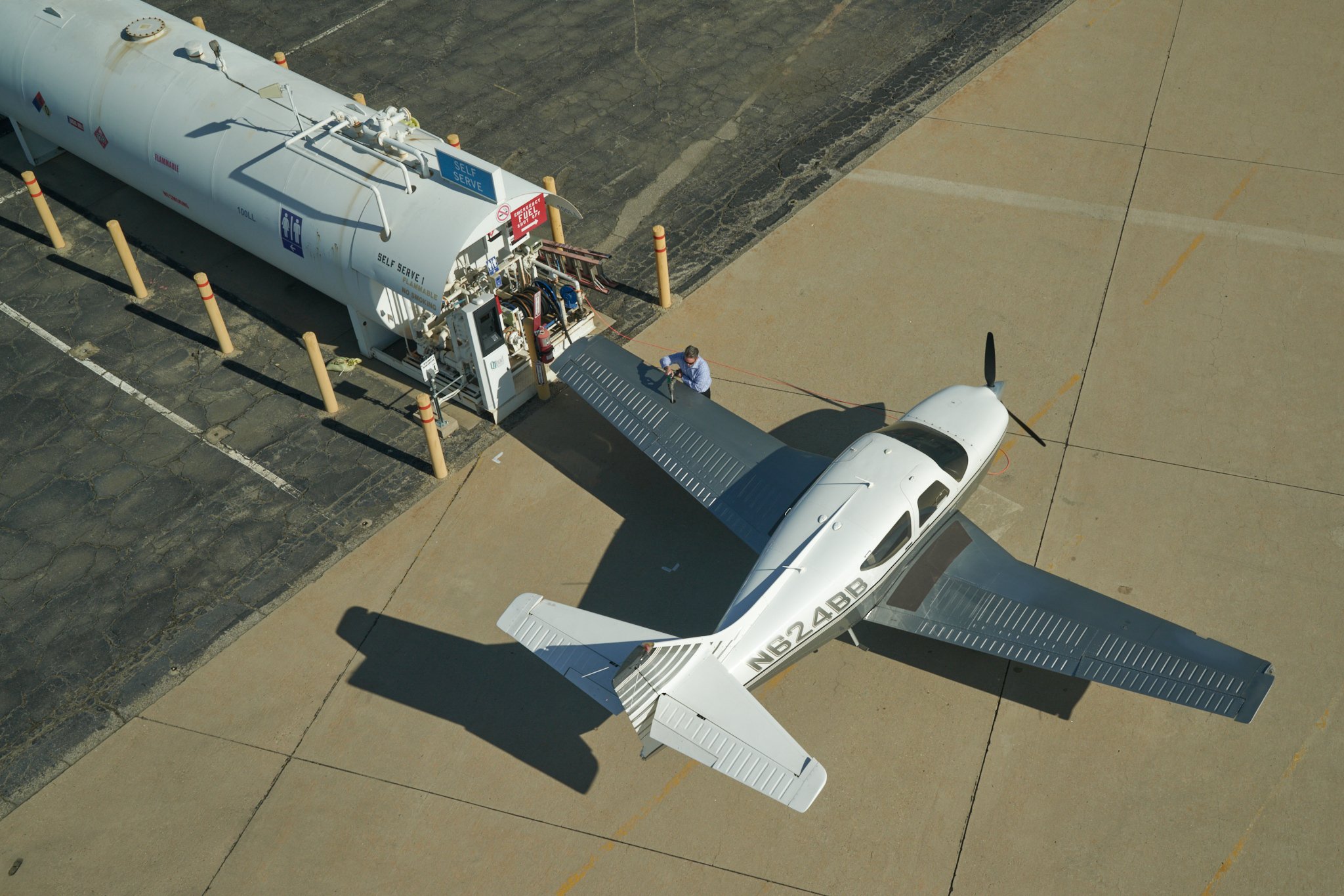 Image of pilot fueling a small single engine plane on the ramp at SBD airport
